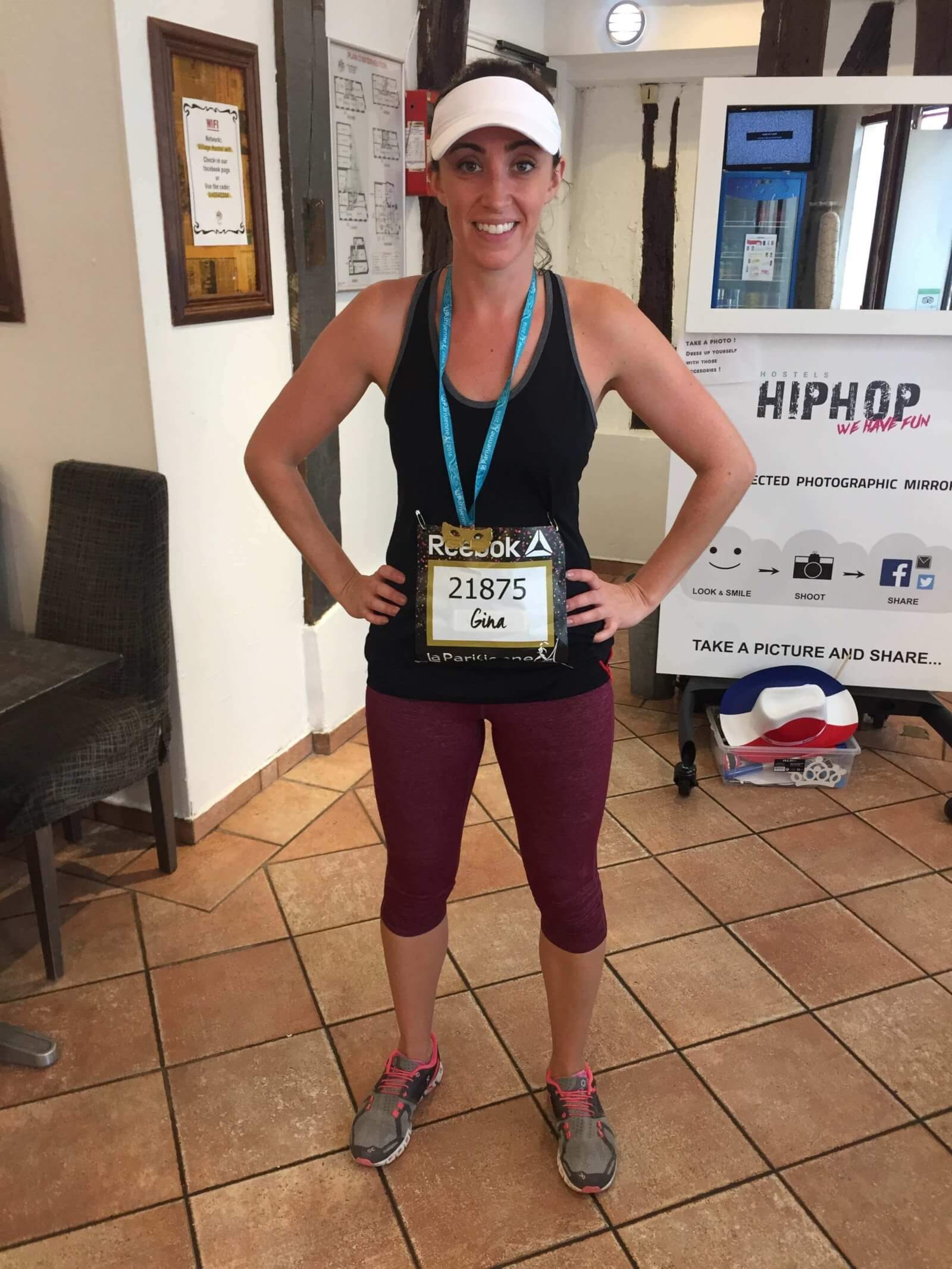 Woman after a road race wearing a medal to stay fit while traveling and running a race
