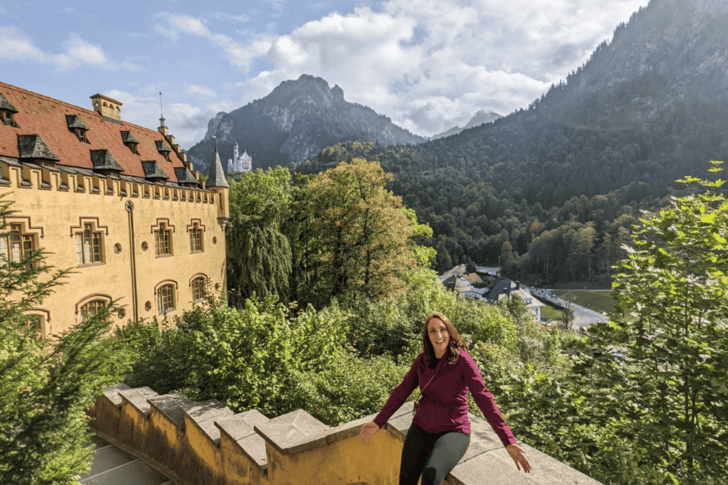 woman sitting on a ledge overlooking a castle in Germany finally not stuck in a rut 