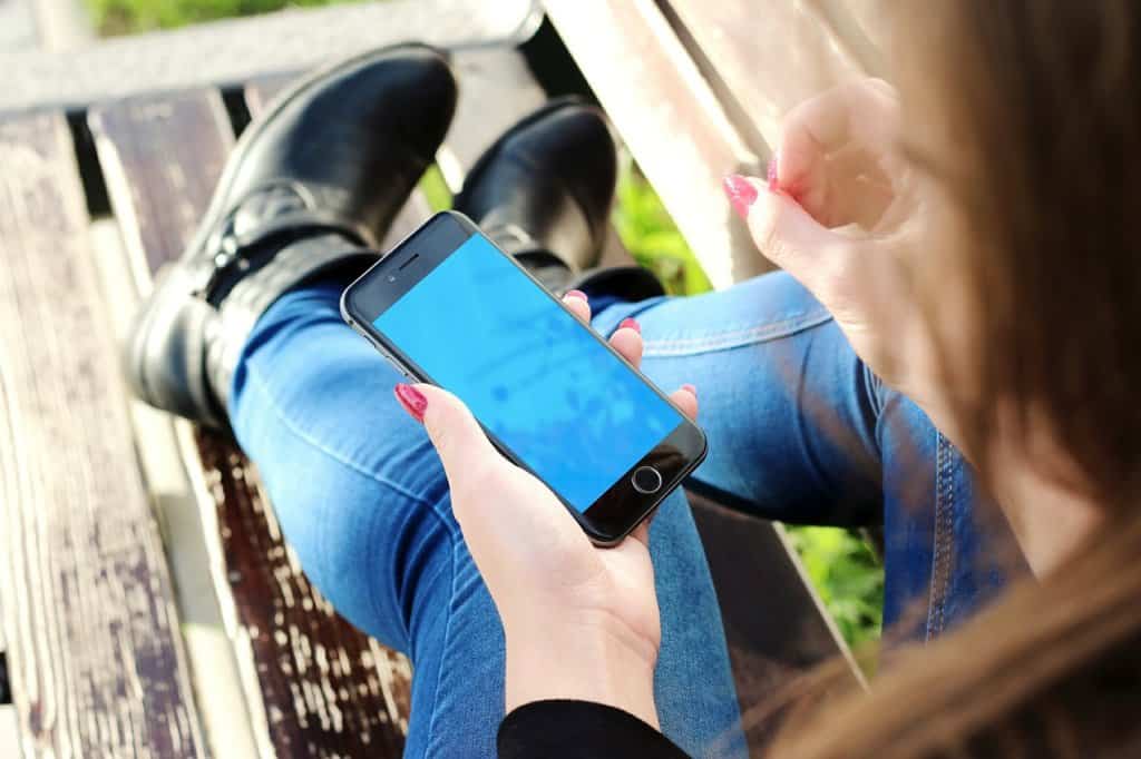 Woman holding an iPhone to help you remember your travels