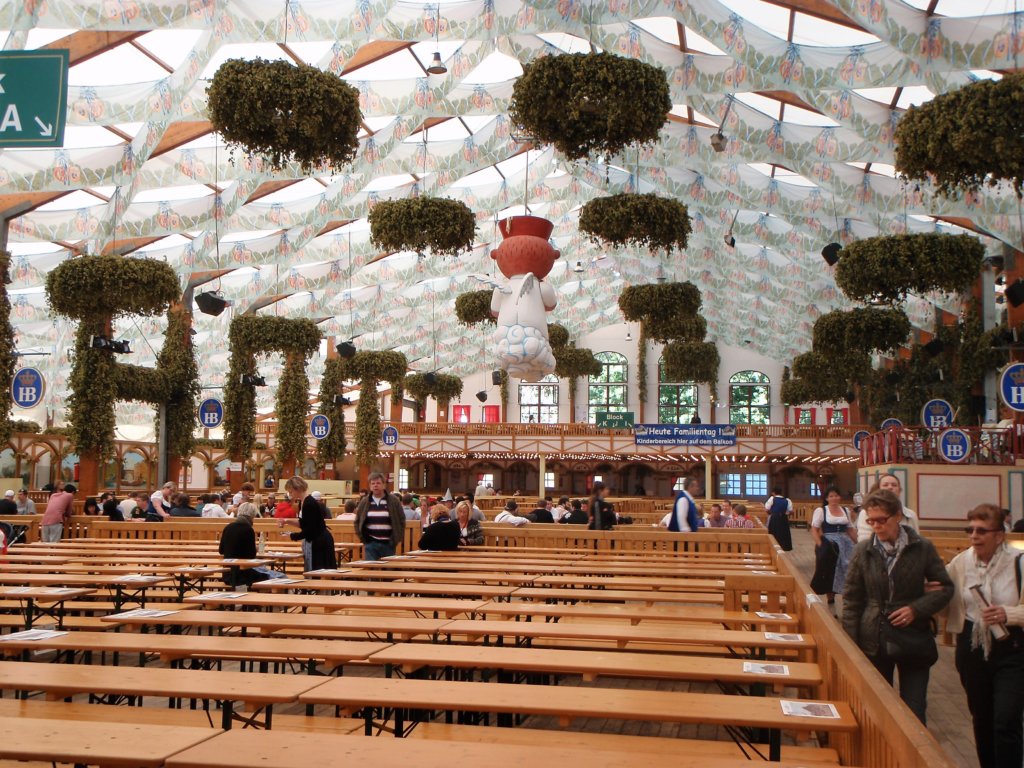 Multiple picnic tables inside of large Oktoberfest tent