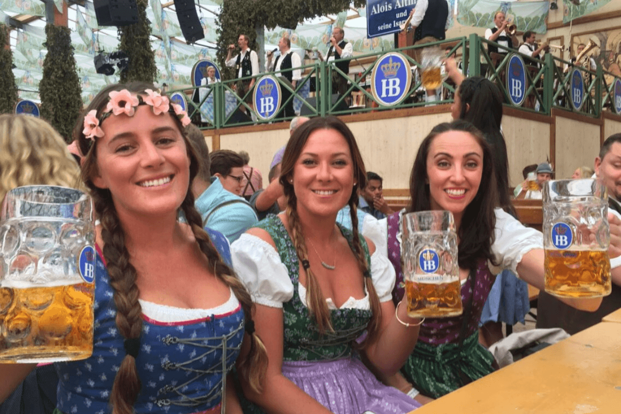 Three girls holding liters of beer at Oktoberfest