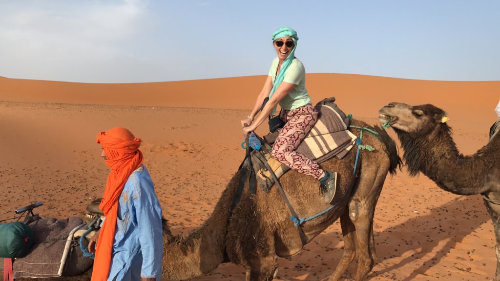 Woman riding a camel making a funny face in Morocco 