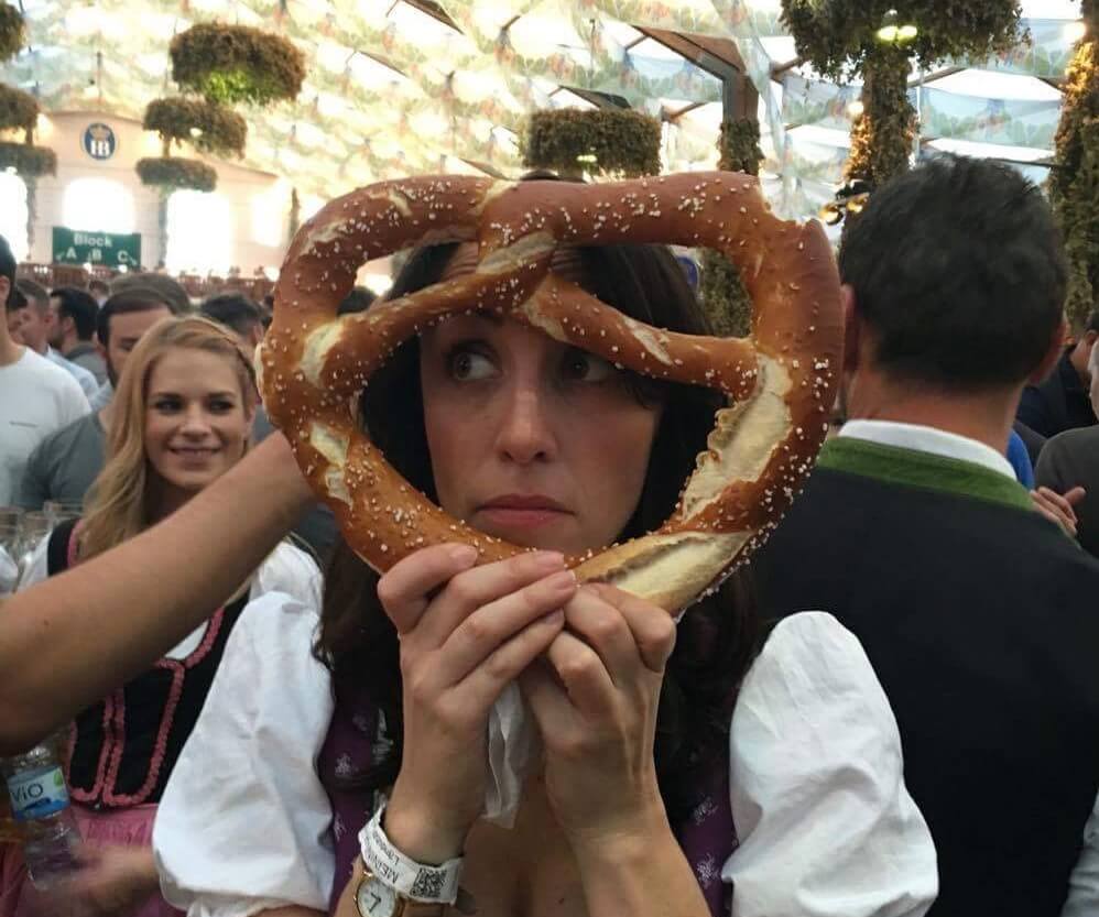 Girl holding a pretzel in front of her face