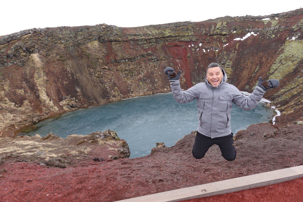 Man jumping in front of a crater