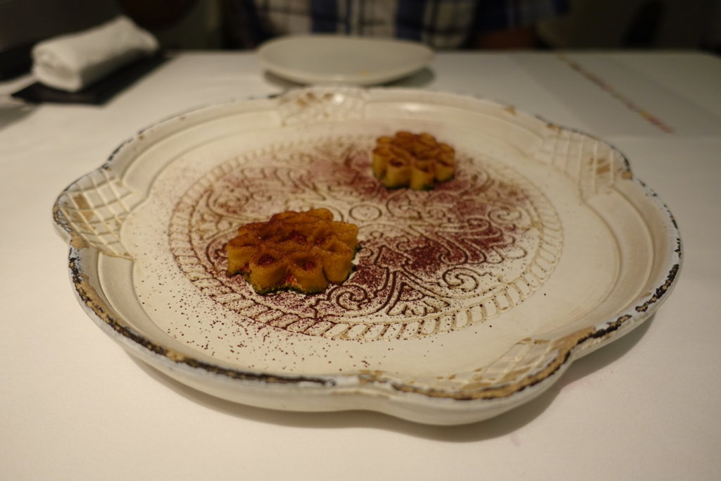 Brown appetizer in the shape of a flower on a white plate