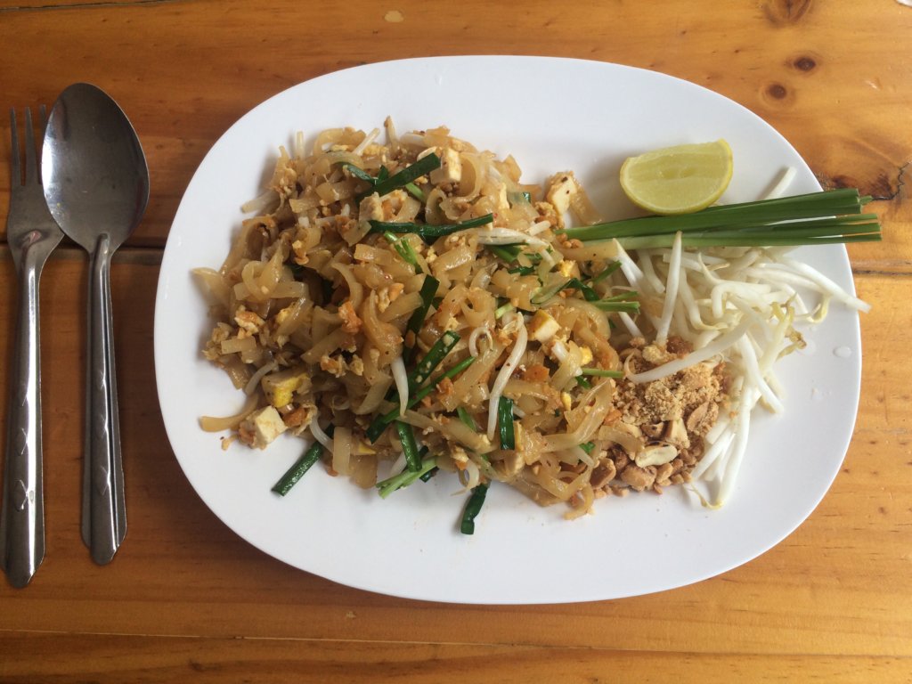A plate of pad thai, noodles, egg and vegetables