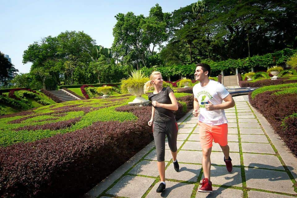 Two people running through the botanical gardens in KL 