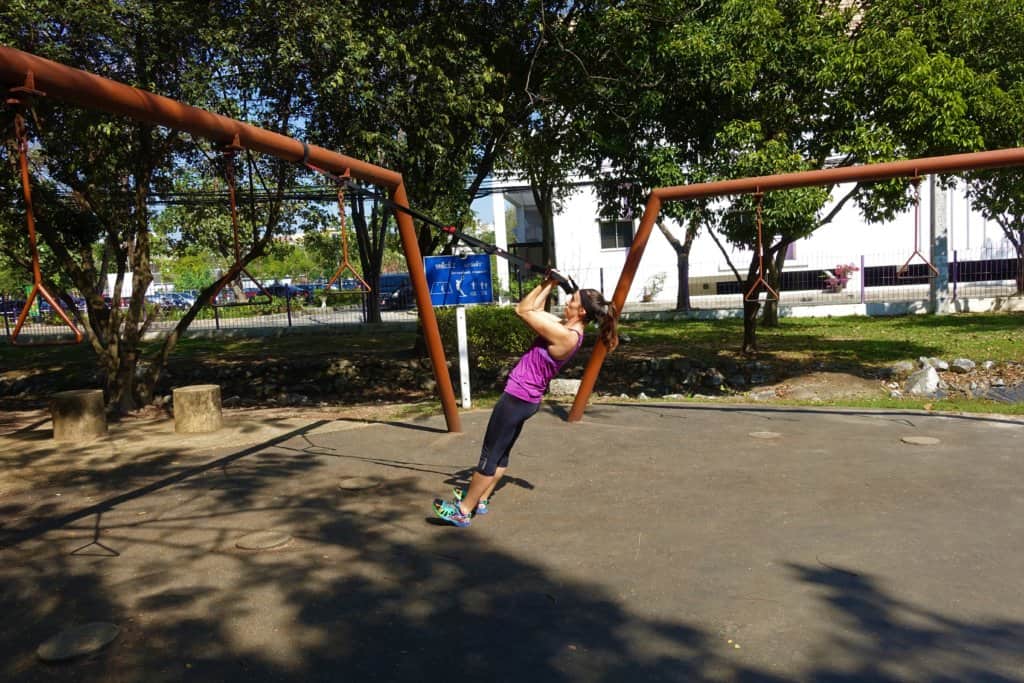 Gina using a TRX strap in a park