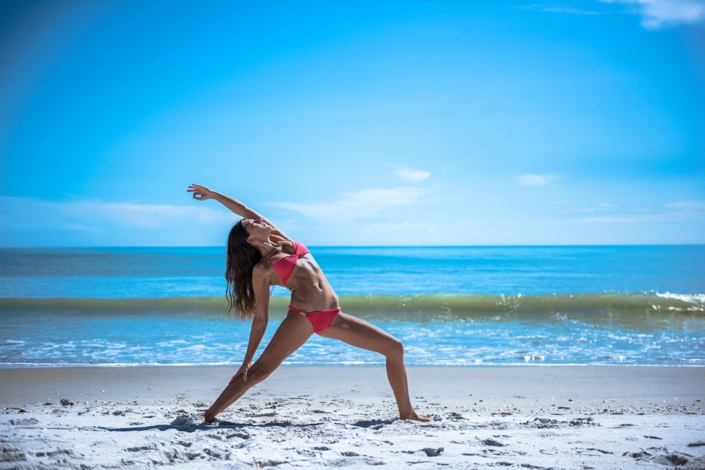 woman doing yoga on beach spending time outdoors 