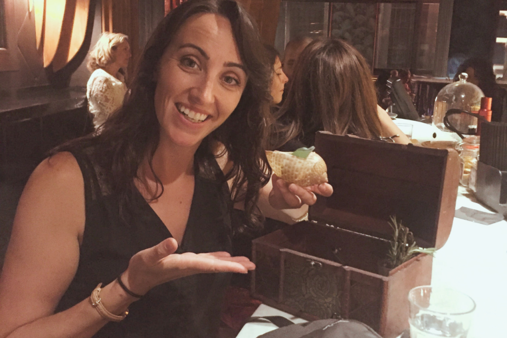 woman holding a cocktail in a shell in Barcelona