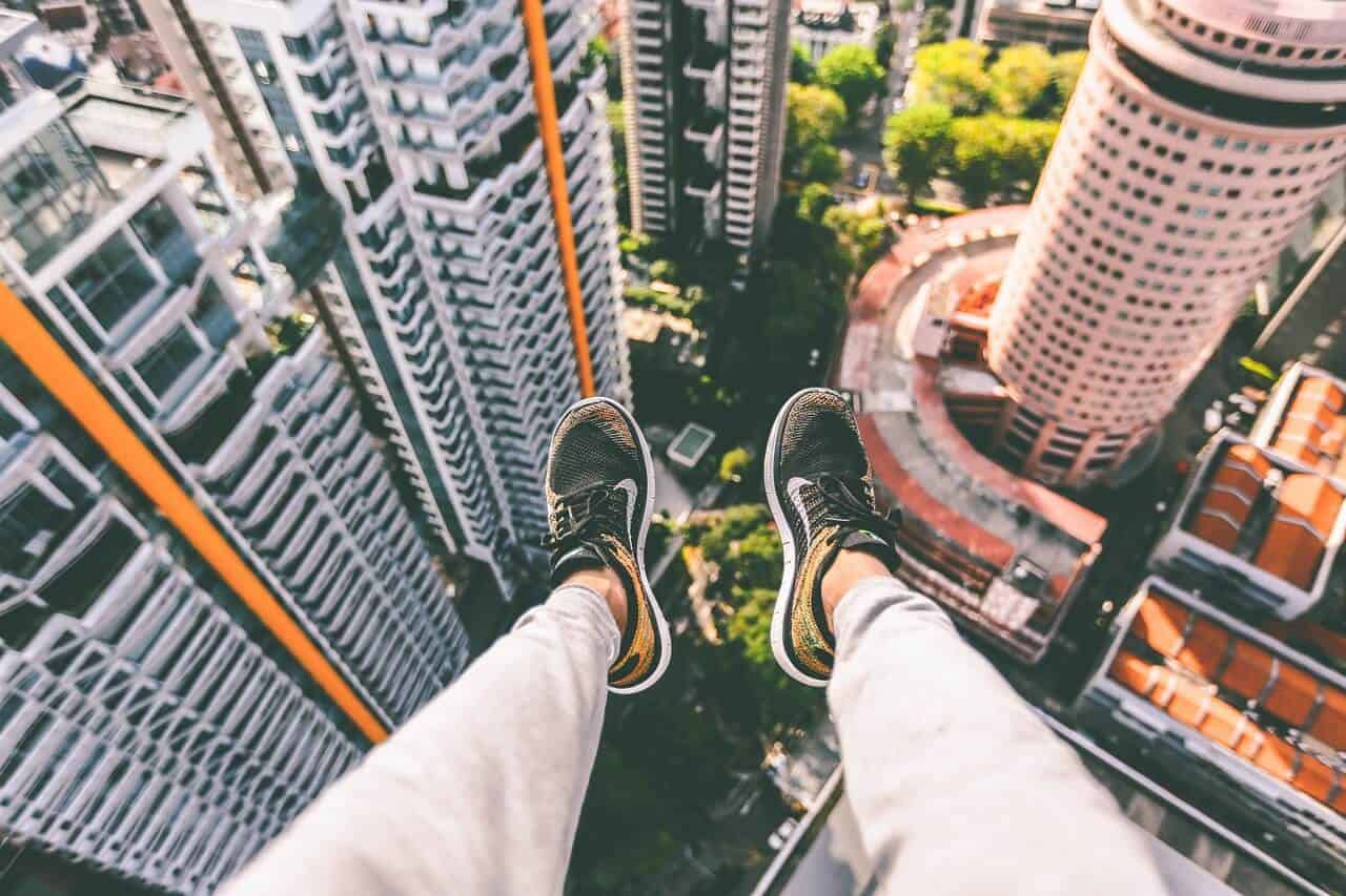 Womans legs dangling over a high building