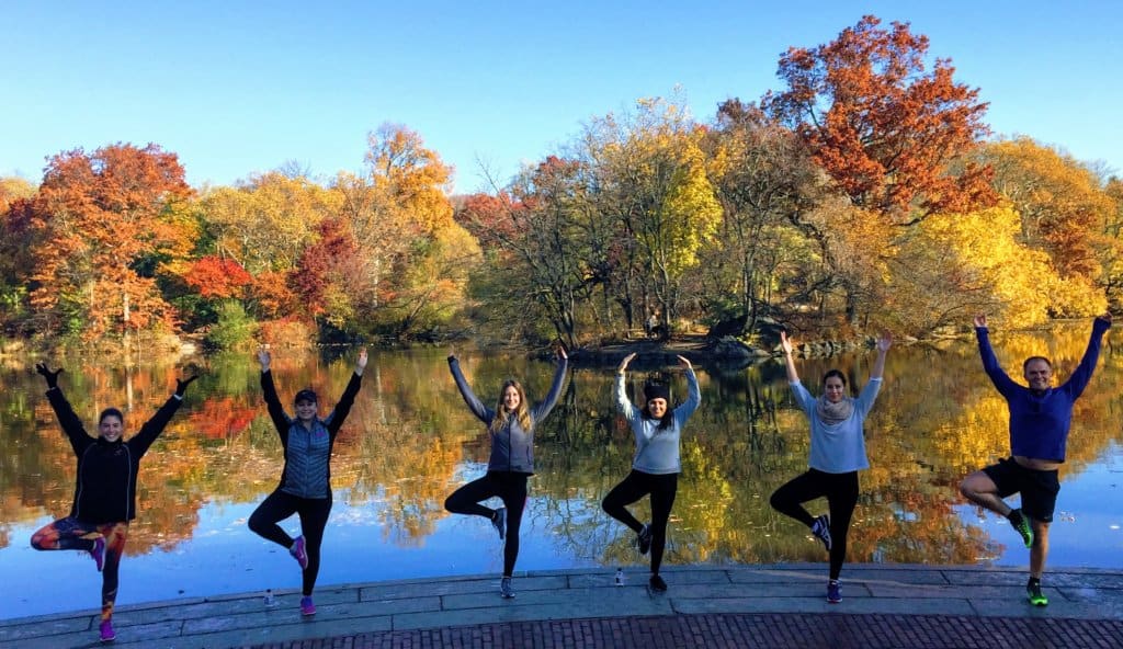 Six woman posing with one foot on their knee and arms raised on a running tour in New York City