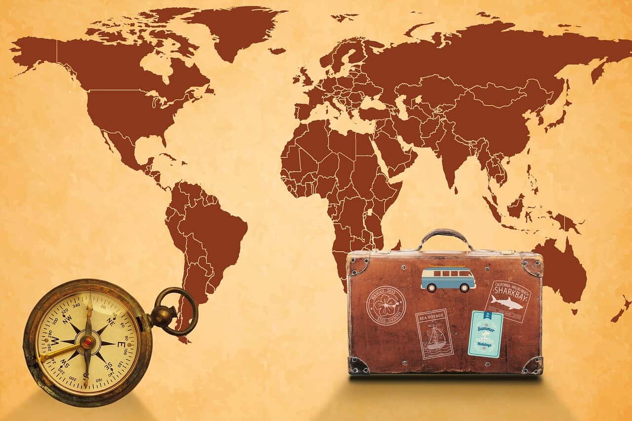 Brown and Tap map of the world with a suitcase and a compass