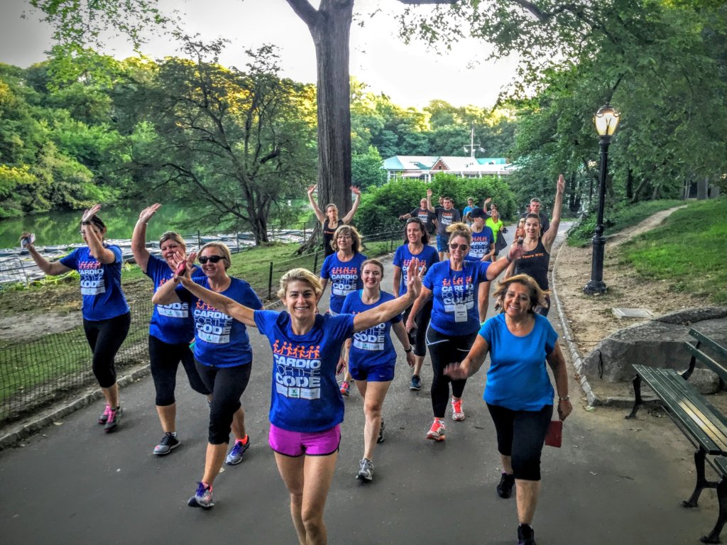 A group of people in blue shirts walking in central park