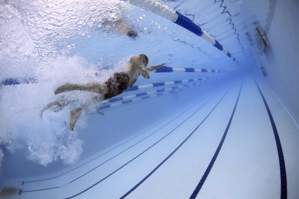 a man swimming in an olympic pool to keep the adrenaline flowing