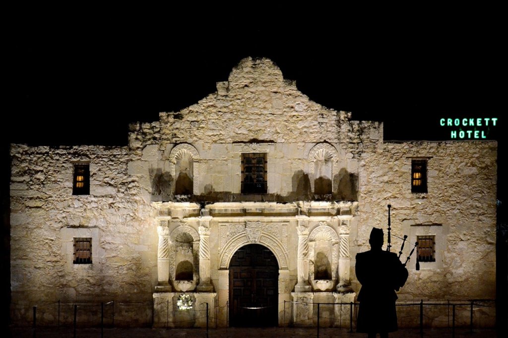 The alamo at night, a concrete building with a triangle top 