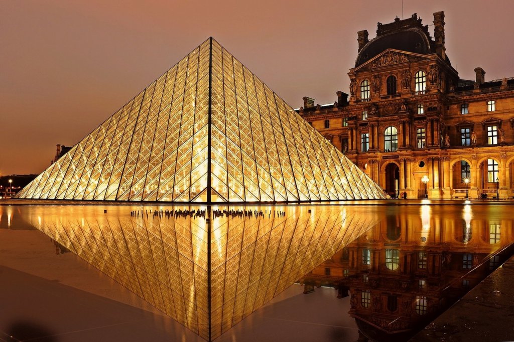 The louvre in Paris at night, one of the best cities for art lovers