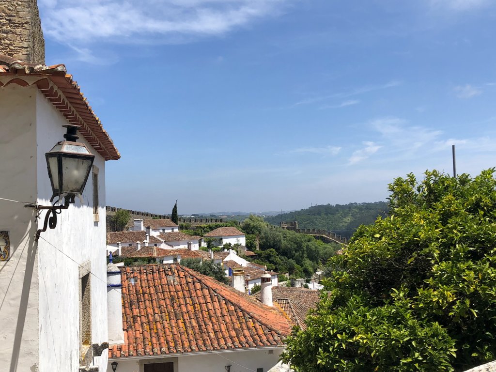 A blue sky and orange colored rooftops in Obidos