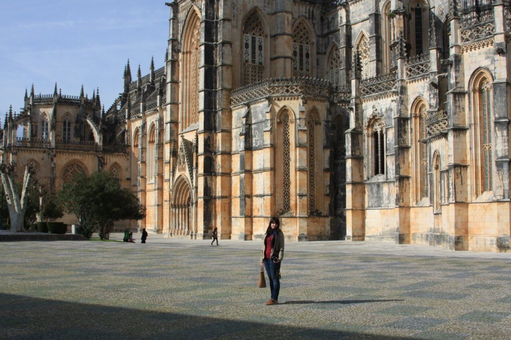 A woman standing in front of a castle in Batalha, one of the bext day trips from Lisbon