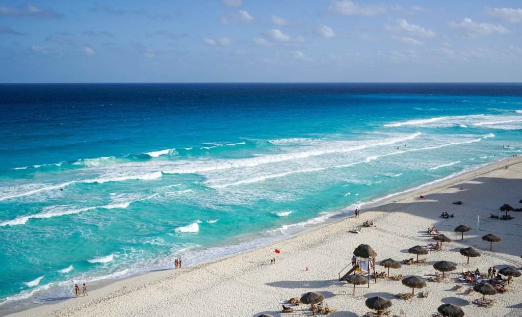 A white sandy beach and blue water in cancun as one of the best yoga destinations for women retreats