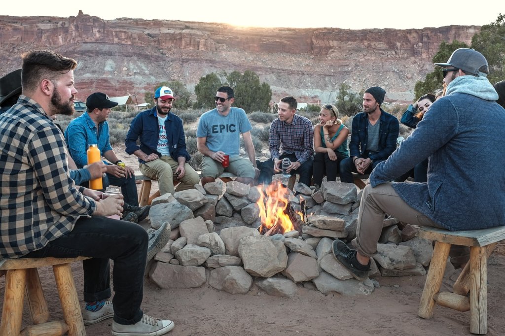 Friends around a campfire discussing how to make their camping trip safe