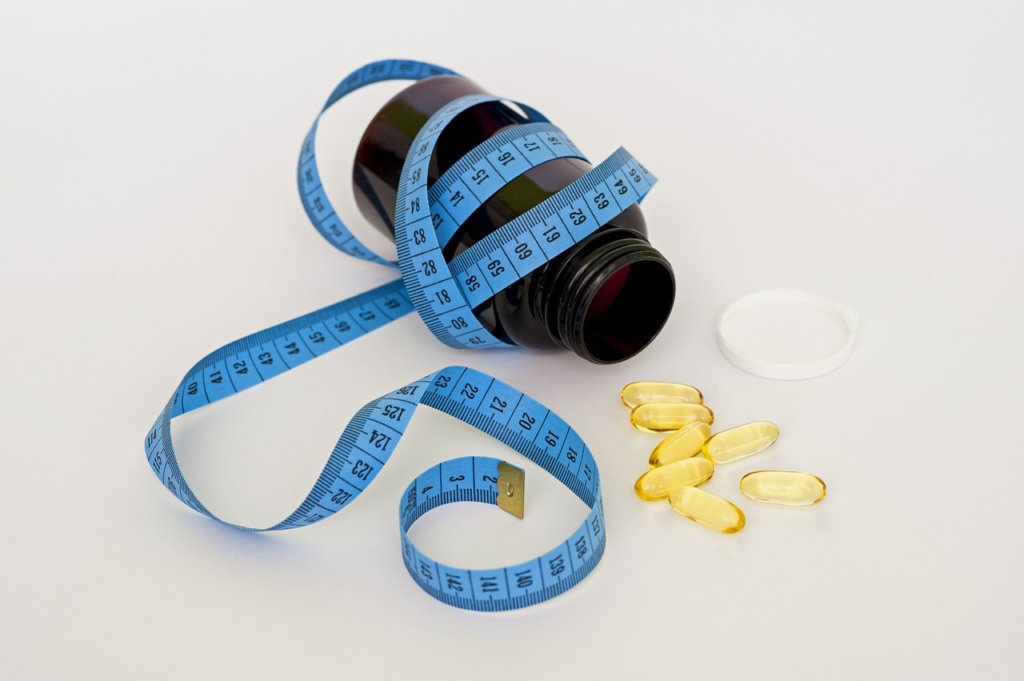 Bottle of pills and tape measure that you have to take on a restricted diet
