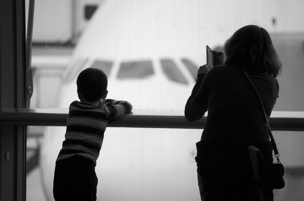 A mom and her son taking a picture of a place for airline companies