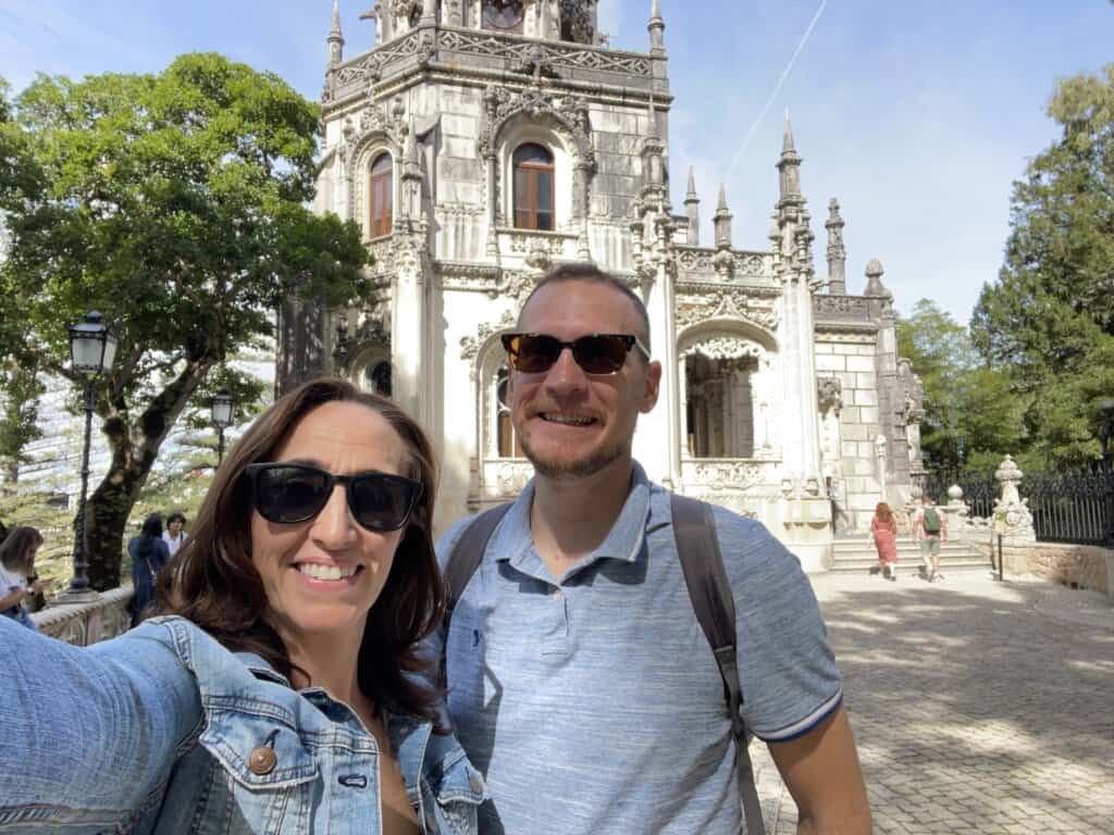 Selfie of Gina and Logan in front of a colorful building 