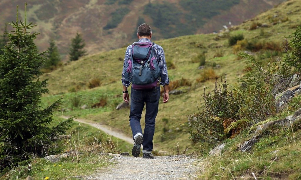 man hiking with a purple backpack 