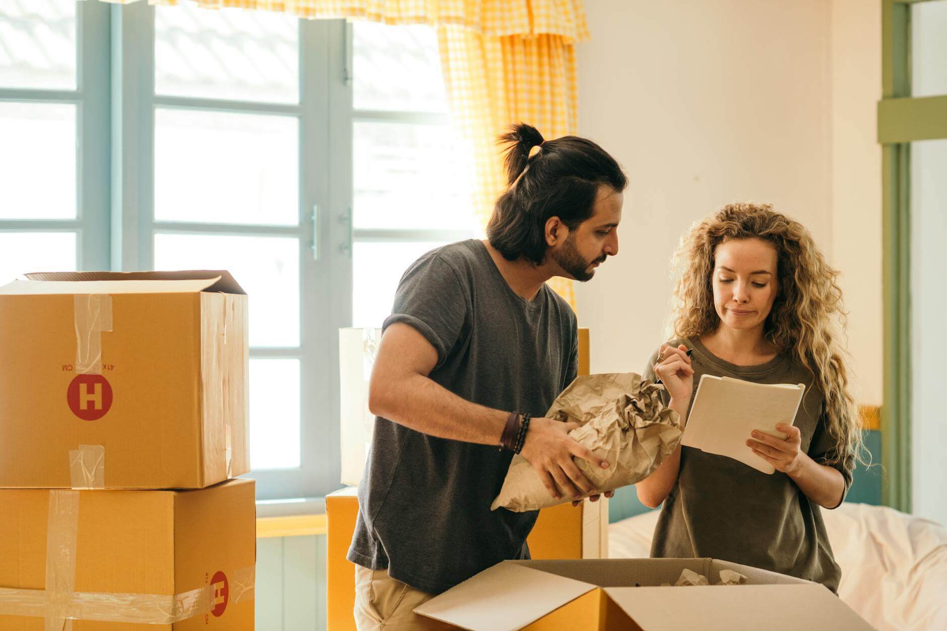 happy couple unpacking boxes in new home thinking about moving abroad with your business