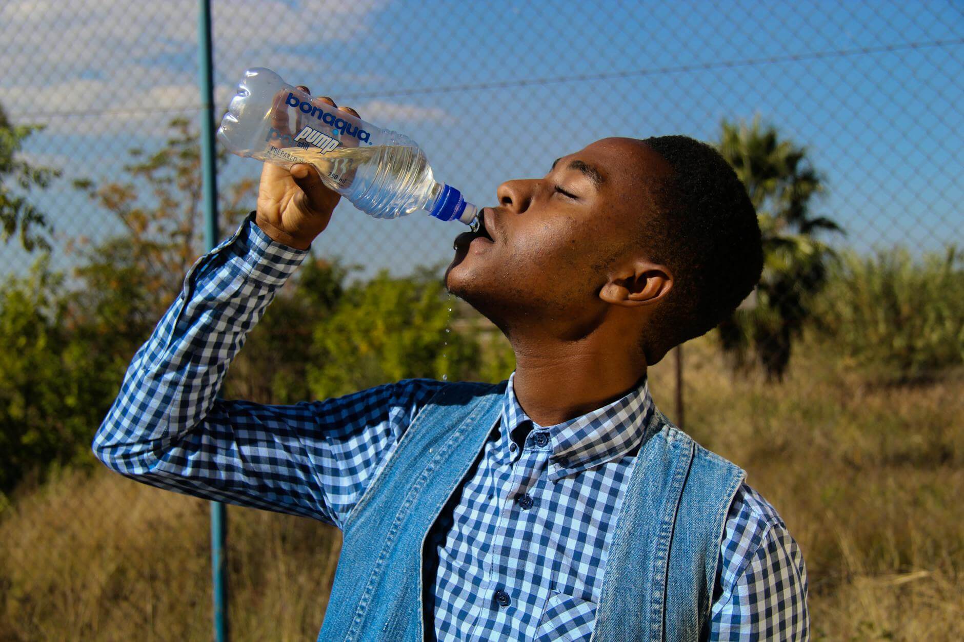  man drinking water to stay healthy while traveling