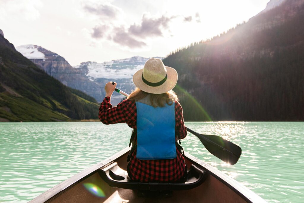 a woman paddling a boat in the lake helping you to quit your job and travel 
