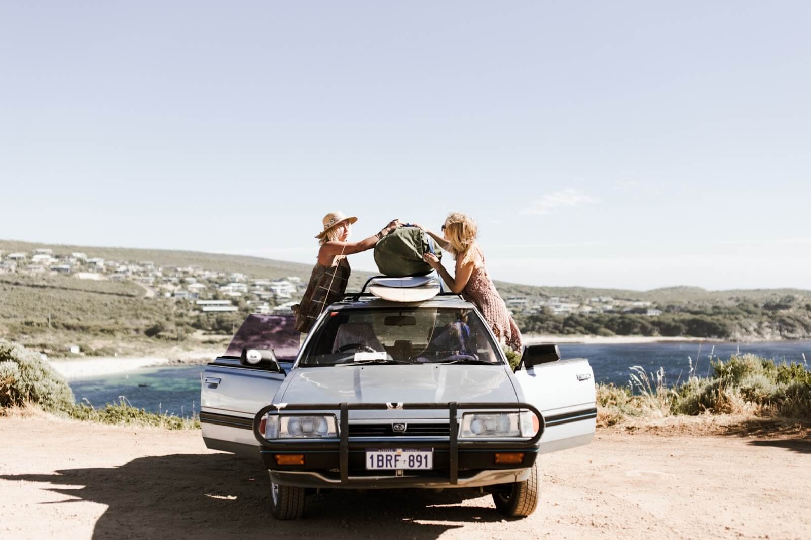 two girls packing a car to learn how to pack your car for a road trip