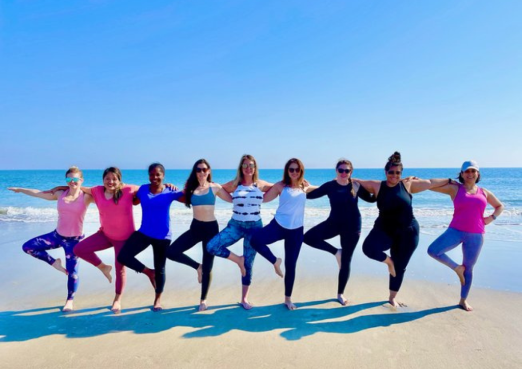 Group of woman doing yoga on the beach in Georgia, USA at a wellness retreats 