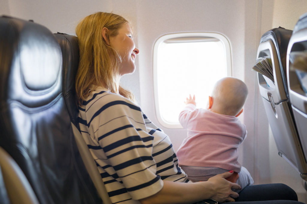 Woman sitting on an airplane traveling with a baby