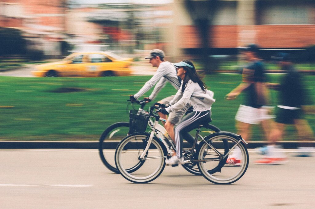 Two people riding a bike showing you how to exercise while traveling