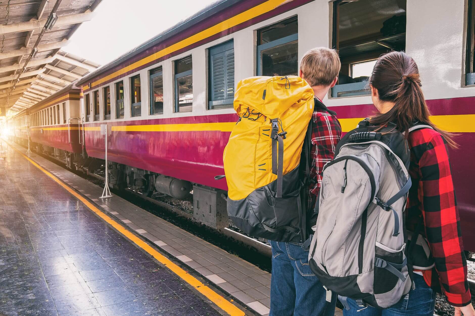 woman and man waiting on train station with their weekend away packing list in hand 
