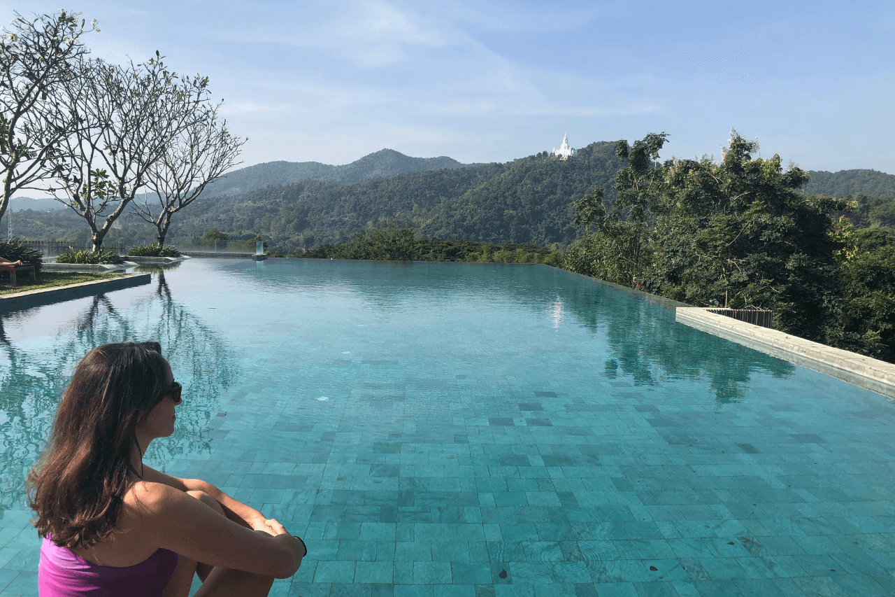 woman looking at a blue pool in thailand on one of her female-focused wellness tours