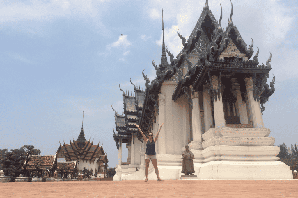 woman standing in front of a white temple in the ancient city in bangkok on her fourth day of her 4 day bangkok itinerary 