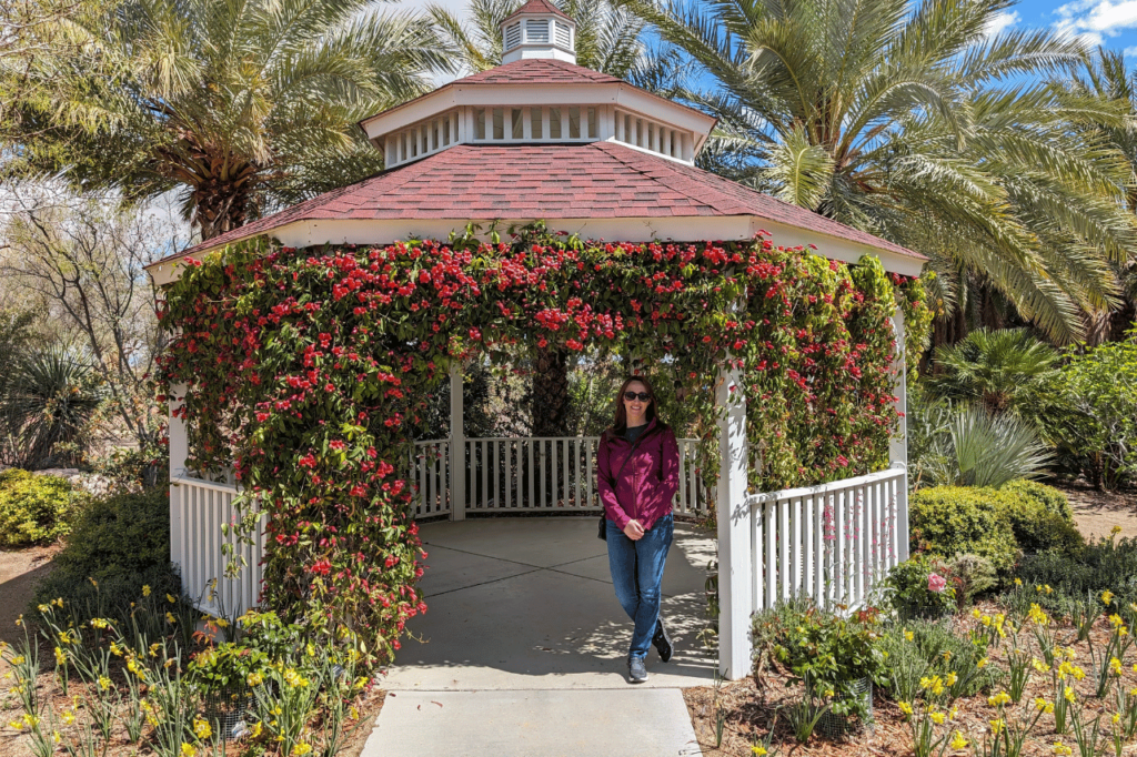 woman standing in a gazebo covered in red flowers