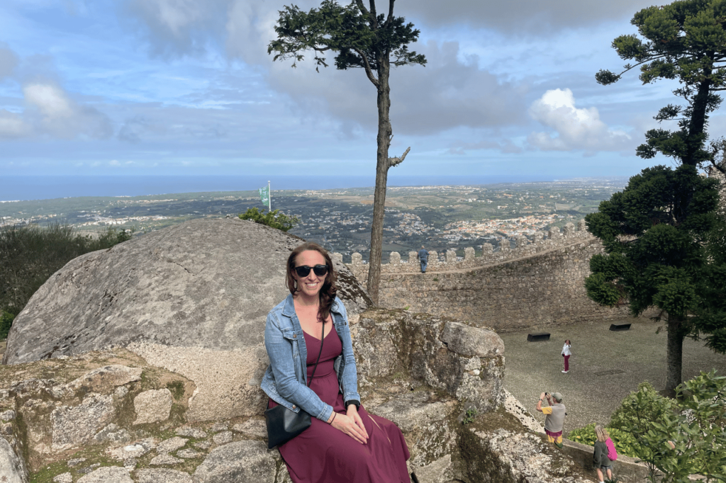woman sitting on a stone chair at the moorish castle in sintra
