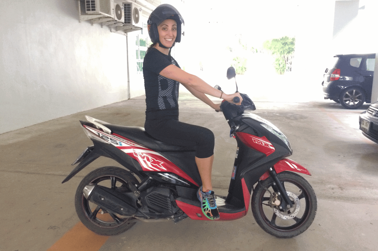 gina-scooter-2 woman on a scooter wearing a helmet showing you how to follow the rules when you rent a scooter in Bali
