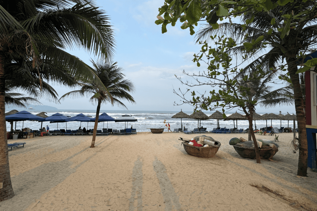 View of My Khe Beach with coconut trees and a coconut boat