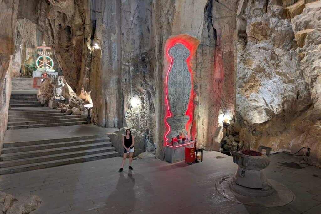 Tourist inside Huyen Khong Cave with altars and illuminated carvings at Marble Mountains Vietnam