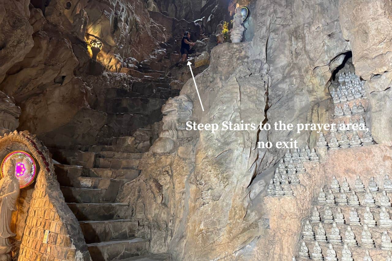 Steep Stairs to Hidden Prayer Area Narrow rocky stairs with sign pointing to secluded prayer zone inside Marble Mountains Vietnam cave