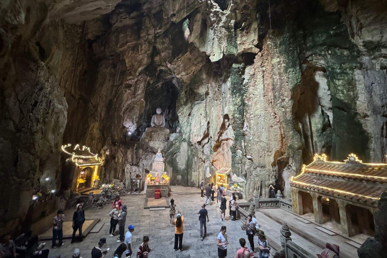 Huyen Khong Cave Interior with Buddha Statue Tourists exploring Huyen Khong Cave with large Buddha statue inside Marble Mountains Vietnam