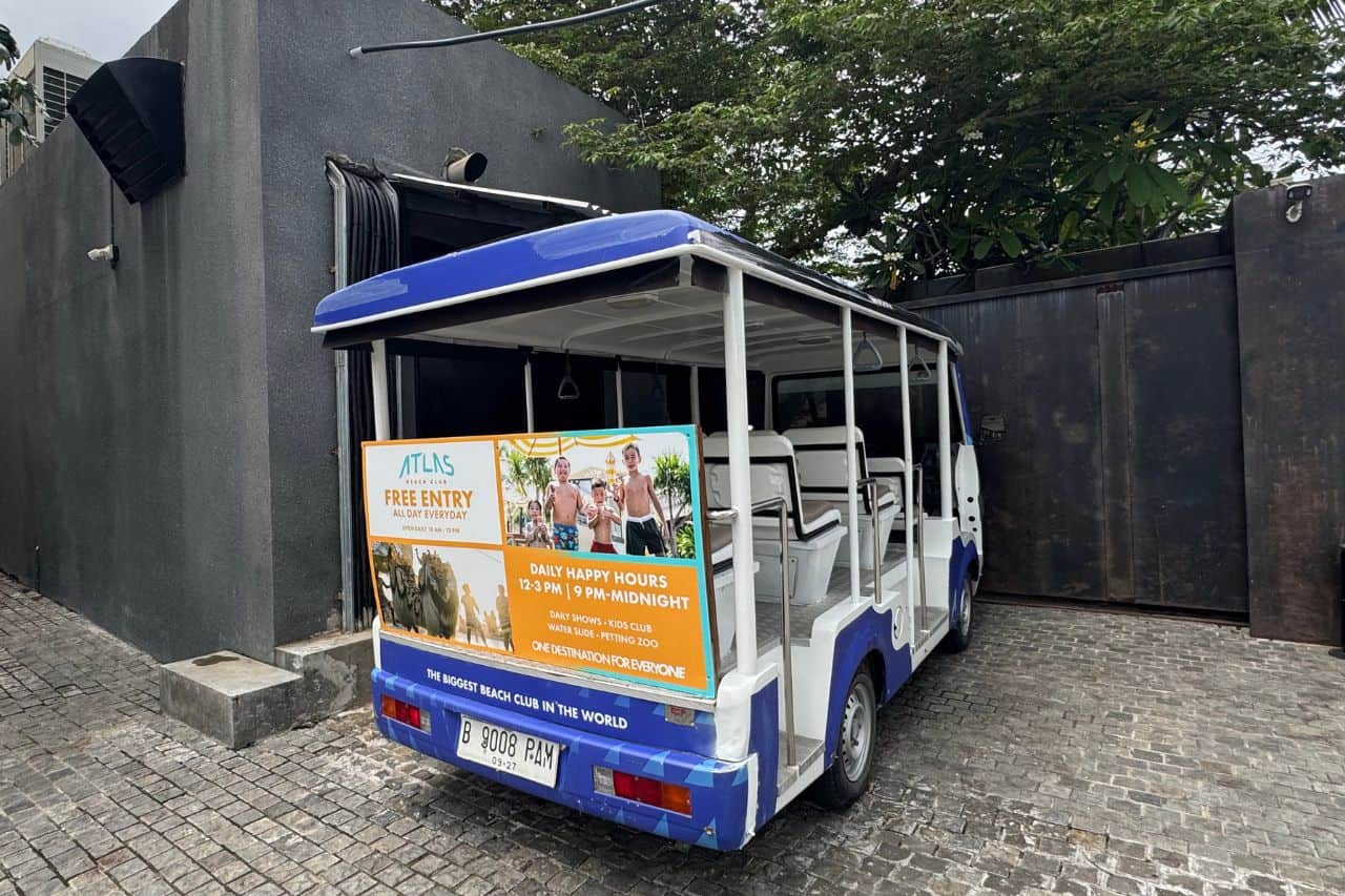 Free Shuttle Service at Atlas Beach Club Blue and white shuttle vehicle offering free rides to Atlas Beach Club visitors in Bali.