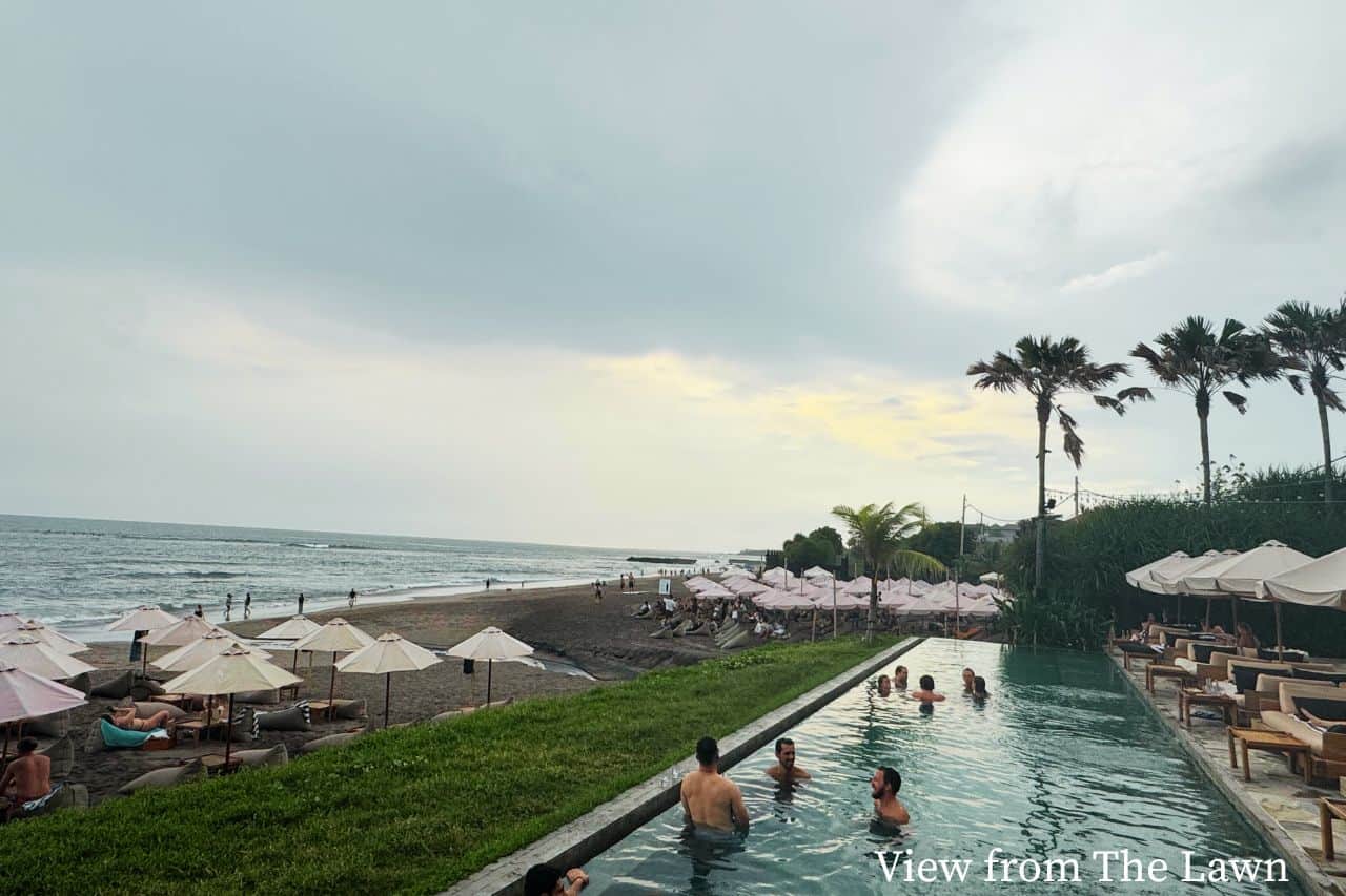 Viw from the Lawn in overlooking the beach in Canggu View of beach in Canggu Bali with swimming pool and people relaxing near the ocean