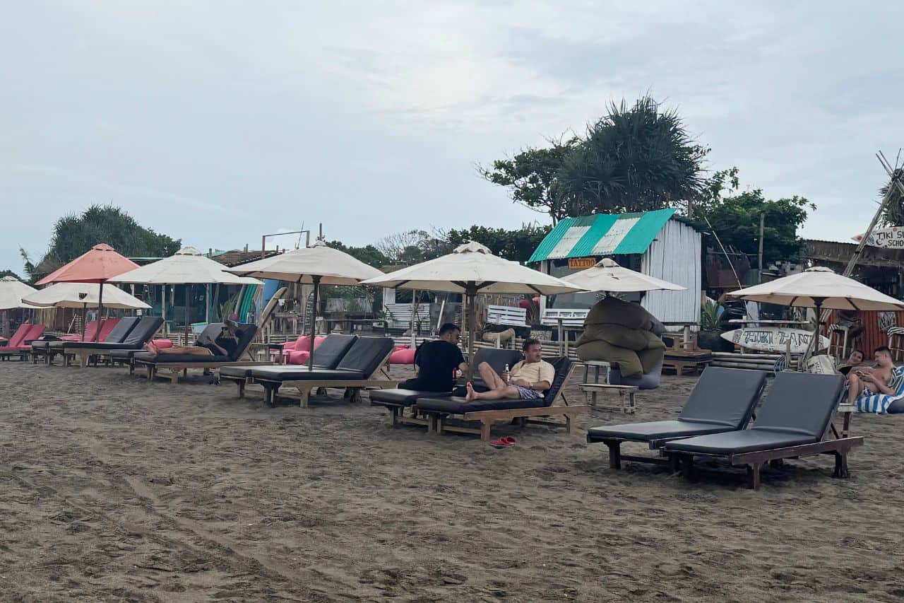 Beach in Canggu Bali with Umbrella Loungers People are relaxing on the beach with umbrellas