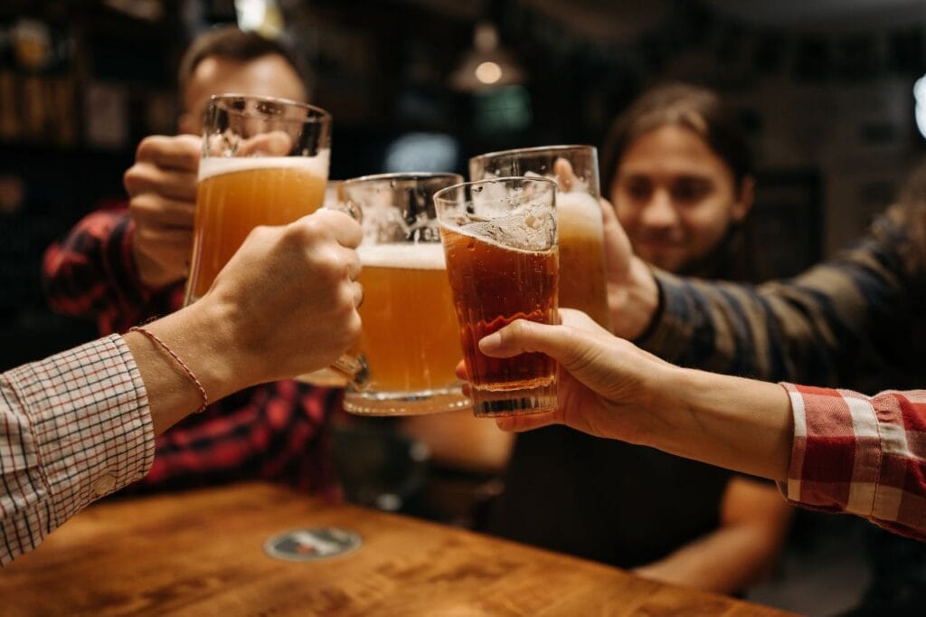 Group of friends clinking beer mugs at a lively bar in Canggu